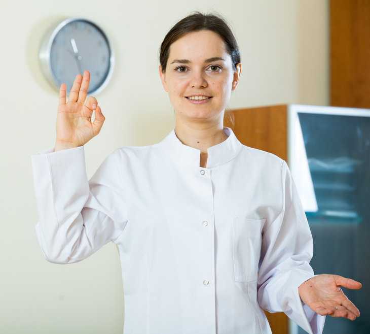 Portrait of professional female brunette doctor smiling in clinic